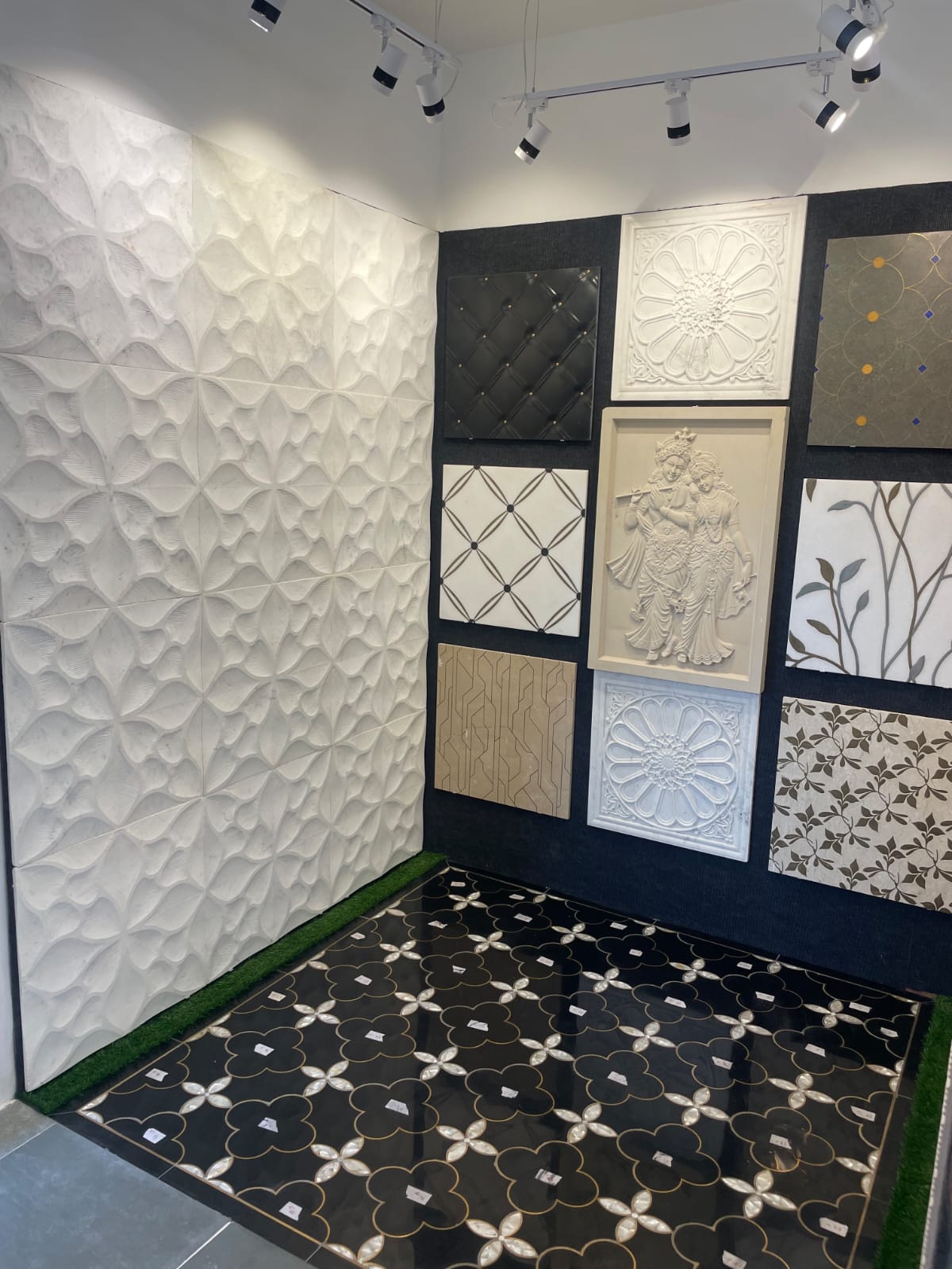 Luxury black marble floor carpet inlay featuring iridescent mother-of-pearl floral scrollwork installed under spotlights
