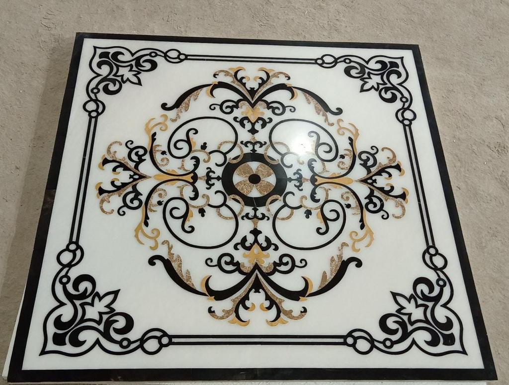 Square luxury marble floor inlay medallion with contrasting black marble and gold ornamental scrolling