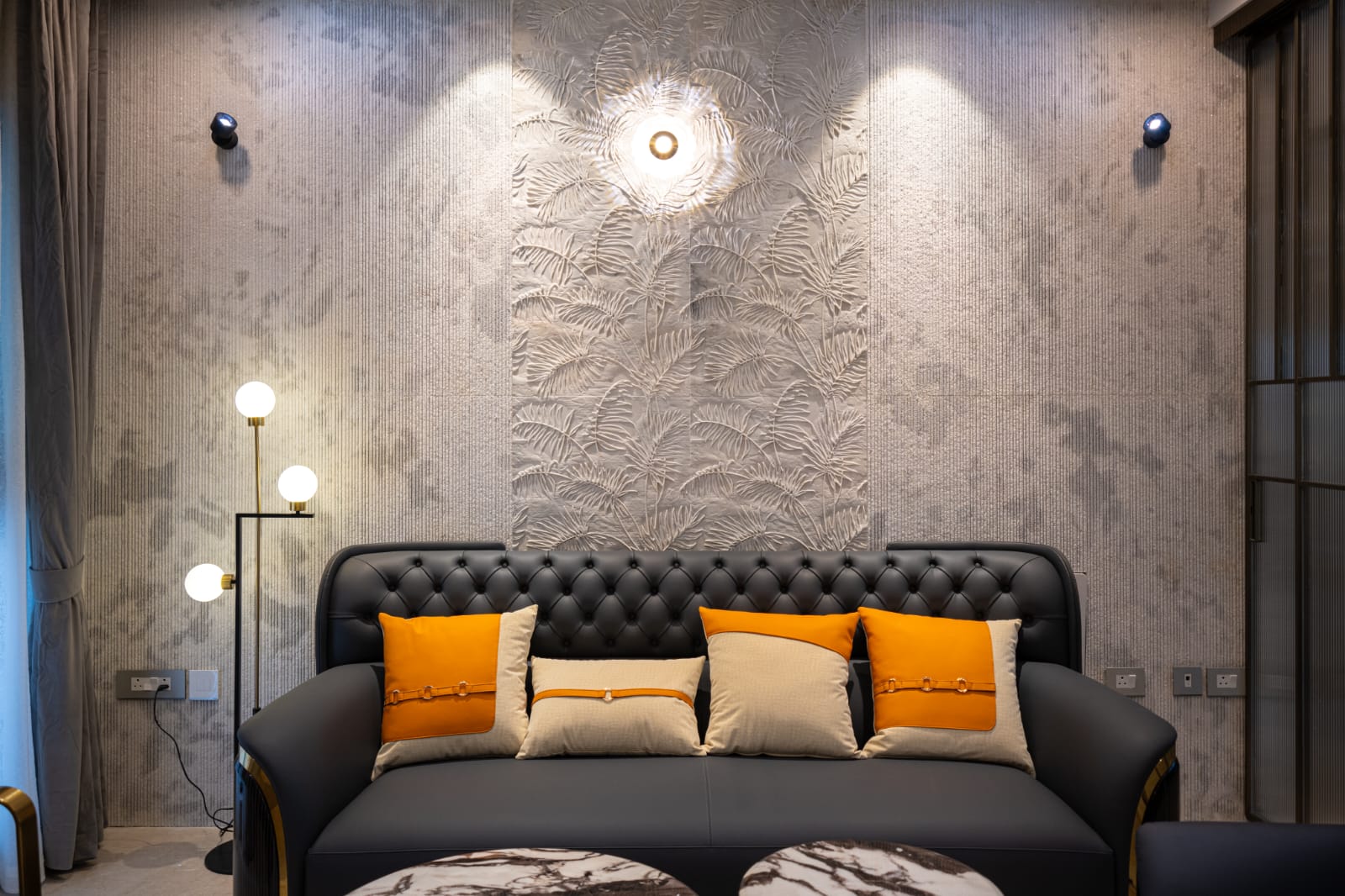 Fluted sandstone living room feature wall with warm lighting and plush lounge seating